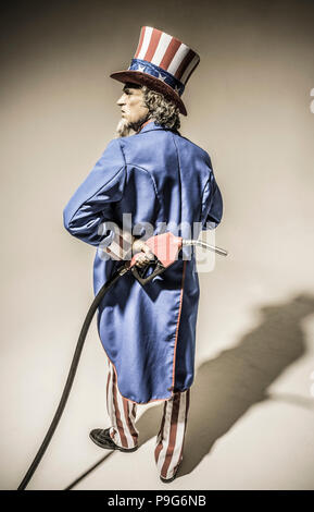 Uncle Sam-Figur von hinten mit einem Benzin pumpe nozzel hinter seinem Rücken gesehen. Stockfoto