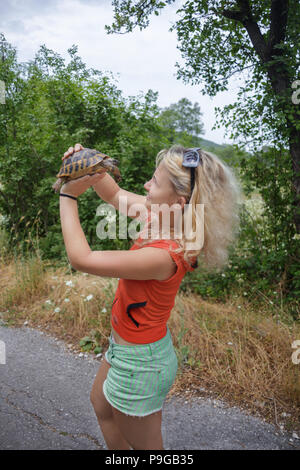 Mädchen spielt mit der Schildkröte auf der Straße Stockfoto