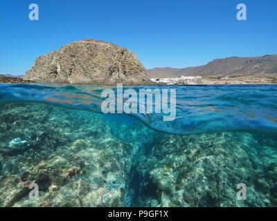 Felsformation an der Küste mit dem Dorf La Isleta del Moro und Felsen unter Wasser, geteilte Ansicht oberhalb und unterhalb der Oberfläche, Mittelmeer, Spanien Stockfoto