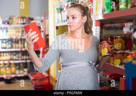 Nach Schwangere ist die Auswahl Produkte aus den Regalen im Supermarkt. Stockfoto