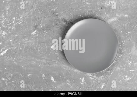 Blick von oben auf die Matte runde leeren Teller auf dunklem Hintergrund. Stockfoto