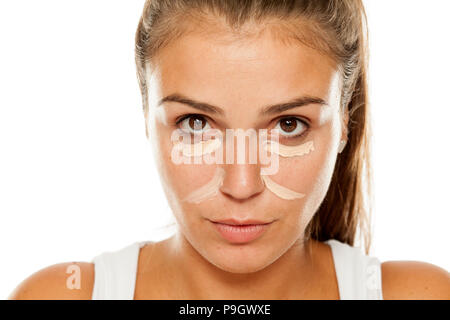 Junge Frauen mit concealer unter die Augen und die Nase posieren Stockfoto