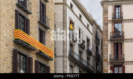 La Senyera (' Flag" auf Katalanisch) und Mannequin auf den Balkonen im Gotischen Viertel von Barcelona. Es ist die offizielle Flagge der Autonomen Gemeinschaft von Catal Stockfoto