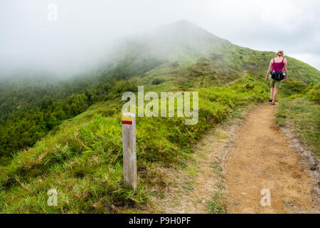 Weibliche Walker auf den Weg an den Hängen des Pico da Vara, der höchste Punkt auf Sao Miguel, Azoren Stockfoto