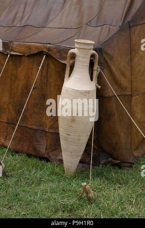 Eine große Keramik Wein Amphore, hielten gegen die Ecke eines Leder römische Armee Zelt. Stockfoto