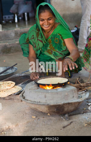 Eine Frau, die chapatis auf offenem Feuer an ihrem Haus in Ahmedabad, Indien. Stockfoto