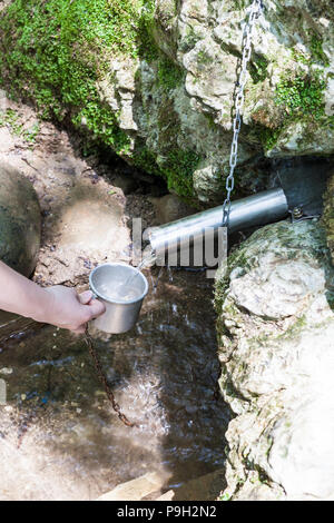 Tour zu Shapsugskaya anomale Zone - Touristische füllt den Becher mit Wasser von Silver Spring (Quelle von Lebenden und Toten Wasser) in Abinsk Ausläufern der Cau Stockfoto