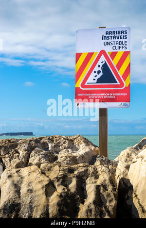 Warnschild Warnung von instabilen Klippen in Englisch und Portugiesisch Stockfoto