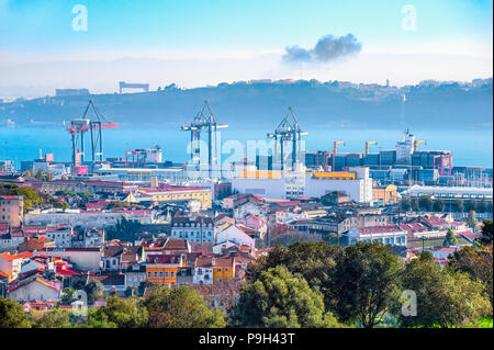 Skyline von Lissabon mit Fracht Krane und Cargo Container im Hafen durch den Fluss Tejo, Silhouette von Almada Bank auf Hintergrund Stockfoto