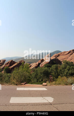 Überschreiten der Red Rock Loop Road auf der Trading Post Trail, gesäumt von großen, roten Felsen, Bäume und Gräser in den Red Rocks State Park, Colorado, Stockfoto