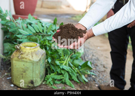 Ein Bauer prüft eine Handvoll Erde auf seiner Farm Baumwolle in Indien. Stockfoto