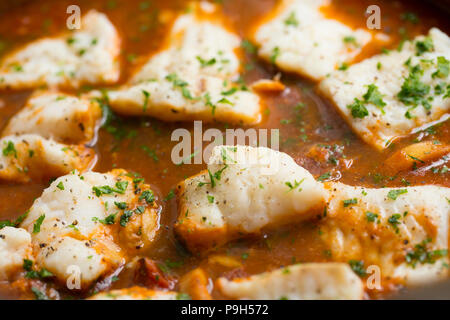 Ein Fisch Eintopf aus Zwiebeln, Knoblauch, Tomaten, gemischte Kräuter und Fisch mit meeraal Steaks, Tintenfischringe und Pollack Filets mit Petersilie garniert. Fi Stockfoto