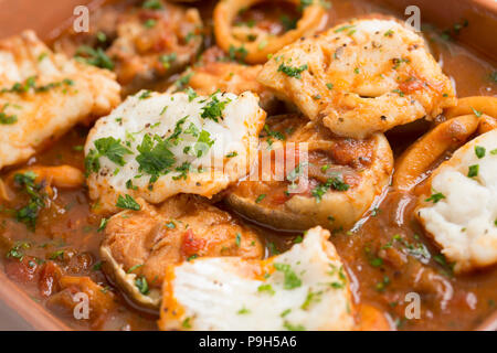 Ein Fisch Eintopf aus Zwiebeln, Knoblauch, Tomaten, gemischte Kräuter und Fisch mit meeraal Steaks, Tintenfischringe und Pollack Filets mit Petersilie garniert. Fi Stockfoto