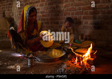 Eine Frau Chapatti kocht auf offenem Feuer, in ihrer Küche im ländlichen Indien. Stockfoto