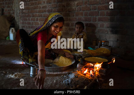 Eine Frau Chapatti kocht auf offenem Feuer, in ihrer Küche im ländlichen Indien. Stockfoto