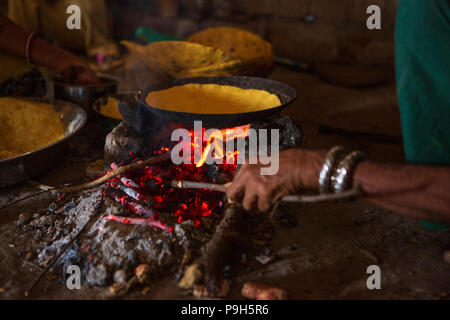 Eine Frau Chapatti kocht auf offenem Feuer, in ihrer Küche im ländlichen Indien. Stockfoto