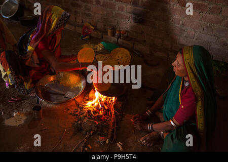 Eine Frau Chapatti kocht auf offenem Feuer, in ihrer Küche im ländlichen Indien. Stockfoto