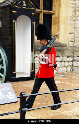 Ein Mitglied der Queen's Guard Märsche und steht an der Tower von London in London, England sentinal. Stockfoto