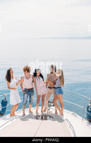 Zwei reichen Kerle in Yacht Party mit schönen Damen, Getränken, Musik und weibliche Schönheit auf dem Segelboot. Außenaufnahme der jungen Menschen posieren Stockfoto