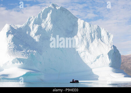 Zodiacs füllen mit Touristen Schwimmer unter enormen Eisberge in Scoresby-sund, Grönland Stockfoto