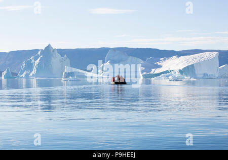 Zodiacs füllen mit Touristen Schwimmer unter enormen Eisberge in Scoresby-sund, Grönland Stockfoto