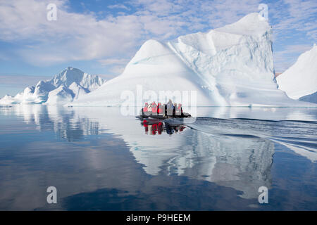 Zodiacs füllen mit Touristen Schwimmer unter enormen Eisberge in Scoresby-sund, Grönland Stockfoto