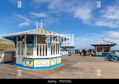 Schlendern Touristen auf Llandudno Pier, ein historisches Wahrzeichen in den Badeort Llandudno, Great Orme, North Wales, Vereinigtes Königreich. Stockfoto