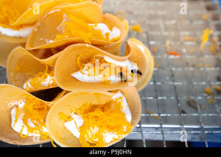 Nahaufnahme Kanom Buang - traditionelle thailändische Dessert knusprige Pfannkuchen mit Mehl, Sahne, und Foi Tanga mit zwei Biene im Hintergrund Stockfoto