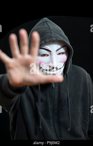 Anonyme hacker trägt eine Guy Fawkes Maske und ein Schwarzer Hoodie Stockfoto