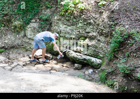 SHAPSUGSKAYA, Russland - Juli 5, 2018: man füllt botle von Silver Spring (Quelle von Lebenden und Toten Wasser) in Shapsugskaya anomale Zone in Abinsk Foo Stockfoto