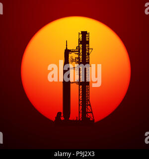 Space Launch System auf Launchpad über Hintergrund der roten Sonne 3D-Abbildung. Stockfoto