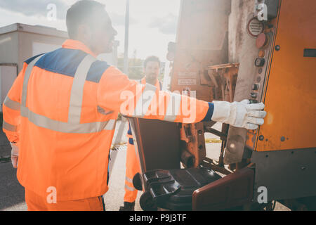 Zwei Müllabfuhr Arbeitnehmer Müll laden in Abfall Lkw Stockfoto