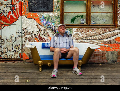 Berlin-Friedrichshain, RAW-Gelände Badehaus Veranda detail von Bar- und Musikzimmer älterer Mann sitzt in der Badewanne als Couch benutzt Stockfoto