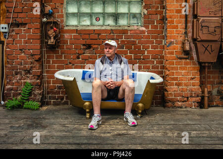 Berlin-Friedrichshain, RAW-Gelände Badehaus Veranda detail von Bar- und Musikzimmer älterer Mann sitzt in der Badewanne als Couch benutzt Stockfoto