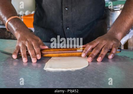 Kochen Teig für das Backen in der Küche, fertige Kuchen zum Backen, Chef's Hände bereiten den Teig für die Herstellung von Kuchen, Brötchen Teig mit einem Nudelholz. Indien Stockfoto