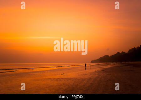 Radhanagar Strand an der Andaman und Nicobar Insel, Indien. Indische Touristen den Sonnenuntergang beobachten. Schöne gelbe Sonnenaufgang auf dem Meer Stockfoto