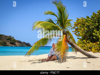 Frau ruht sich im Schatten von Palmen am Strand in Britische Jungferninseln Stockfoto