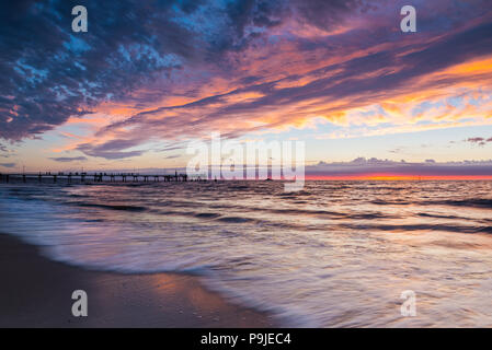 Sonnenuntergang an der immer beliebten Strand von Glenelg und Steg, in der Nähe von Adelaide, South Australia. Stockfoto
