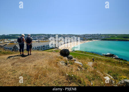 Ein paar stehen und den Blick über Porthmeor Beach in St Ives, Cornwall im Sommer Stockfoto