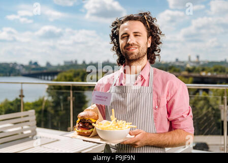 Freundlich lächelnden Kellner, um für seine Besucher Stockfoto