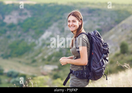 Mädchen Tourist mit einem Rucksack lächelnd in die Natur. Stockfoto