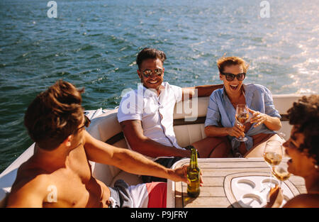 Junge Leute Party auf einem Boot. Männer und Frauen lachen und geniessen bei Yacht Party. Stockfoto