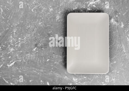 Blick von oben auf die Matte rechteckig leeren Teller auf dunklem Hintergrund. Stockfoto