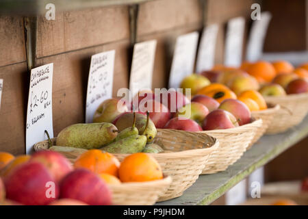 Schalen von Obst zum Verkauf einschliesslich Orangen, Birnen und Äpfel auf dem Display außerhalb eines Obst- und Gemüsehändler shop in North Dorset England UK GB. Stockfoto