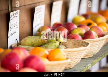 Schalen von Obst zum Verkauf einschliesslich Orangen, Birnen und Äpfel auf dem Display außerhalb eines Obst- und Gemüsehändler shop in North Dorset England UK GB. Stockfoto