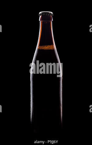 Braune Flaschen Bier auf schwarzem Hintergrund, mit leuchtenden Kanten und Schaum Stockfoto