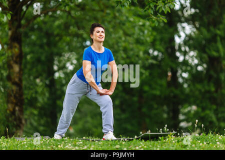 Ältere Frau Trainieren in Park. Ältere weibliche tun Fitness Übungen im Freien. Gesunden Lebensstil Konzept. Copyspace. Stockfoto