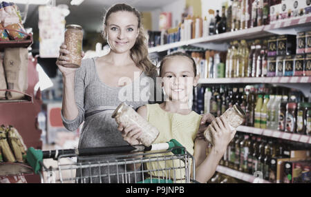 Fröhliche positive Mutter mit Jugendmädchen Demonstration ihrer Wahl in Essen Abteilung im Supermarkt Stockfoto