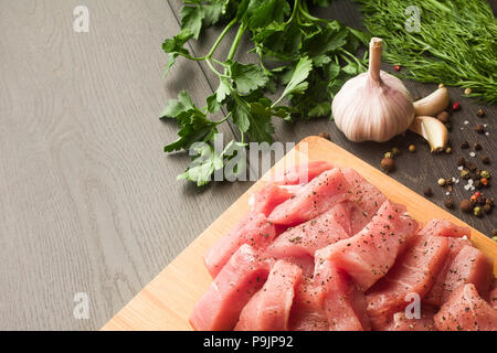 Saftiges rohes Fleisch mit Gewürzen, Pfeffer, Salz und Kräutern liegt auf einer Stockfoto