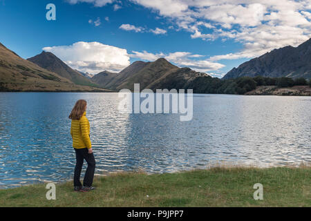 Weibliche Wanderer stehen am Ufer des Moke Lake in der Nähe von Queenstown, Lake mit Bergen, Otago, Südinsel, Neuseeland Stockfoto